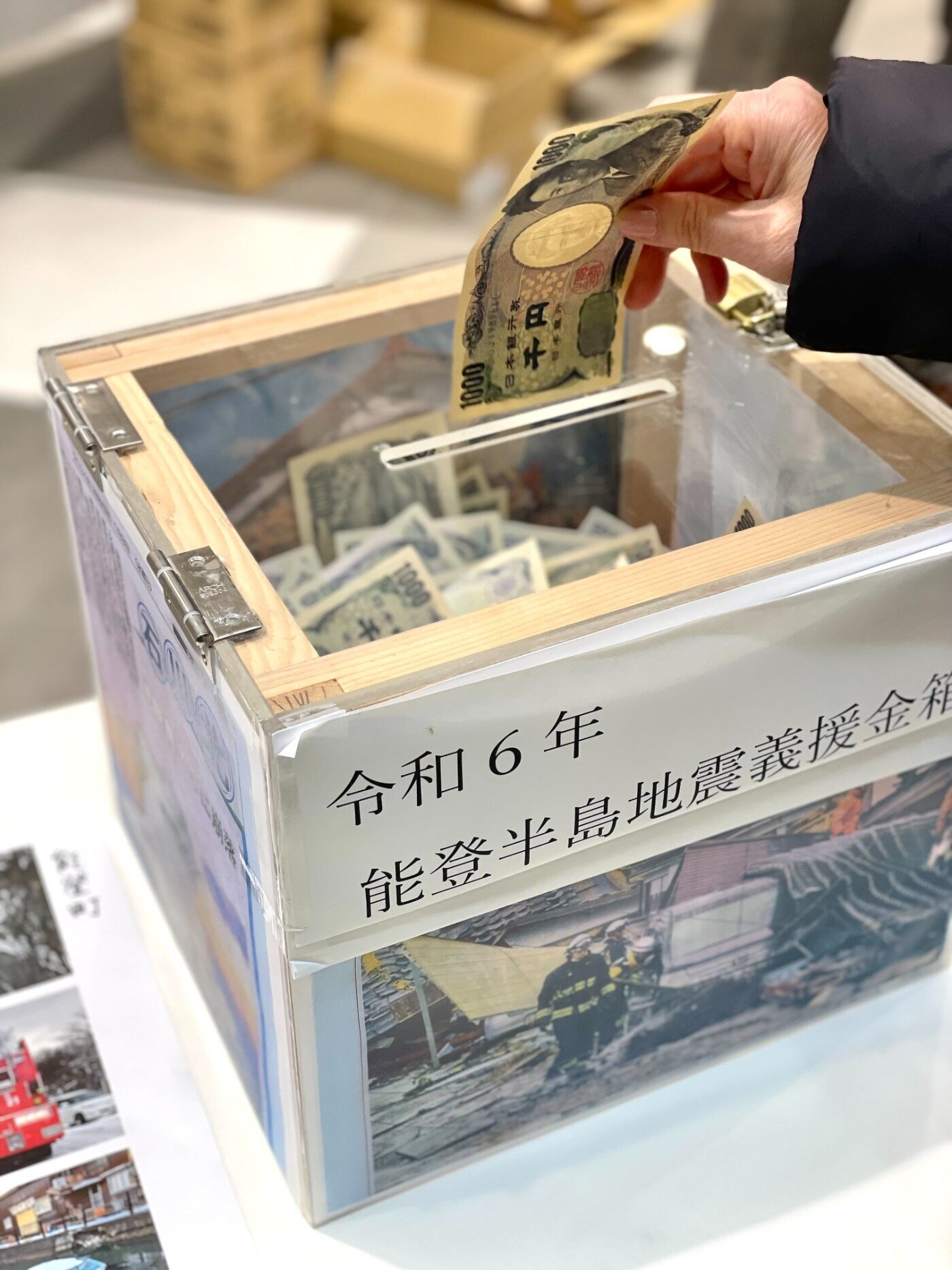 義援金箱にお札を入れるお客様
